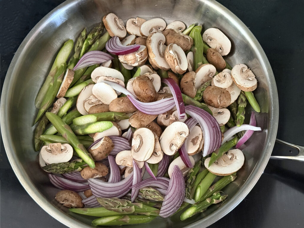 Asparagus, Mushrooms, and Red Onions in stainless steel pan