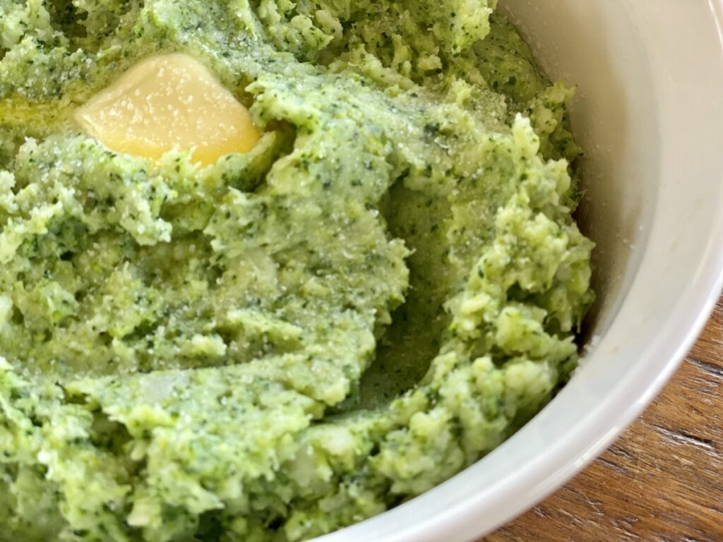 Very close up image of Potato Broccoli Mash Up with a pat of melting butter.