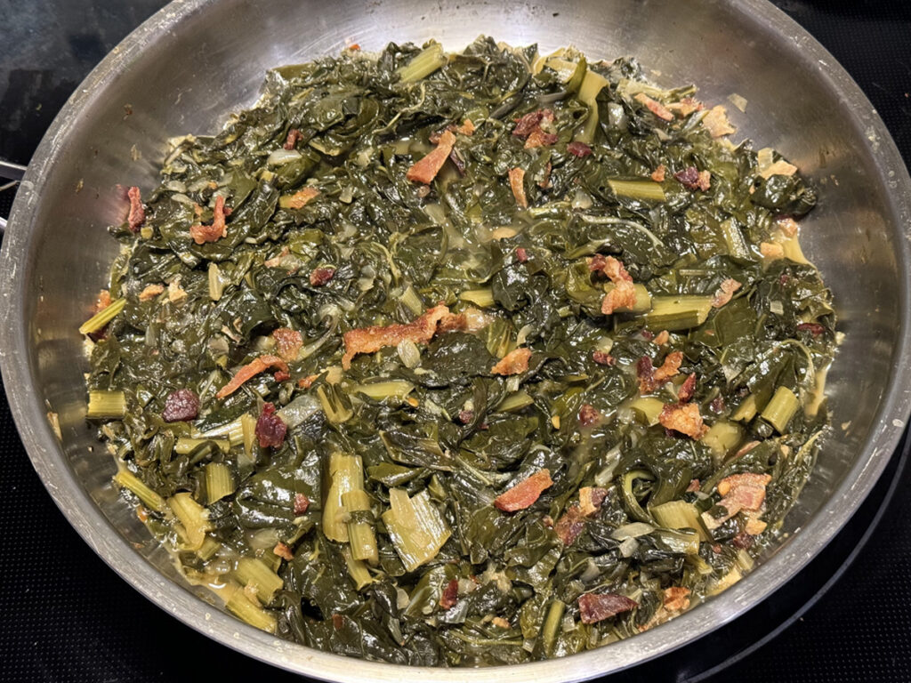 Weeknight Southern Greens cooked in stainless steel pan sprinkled with bacon crumbles.